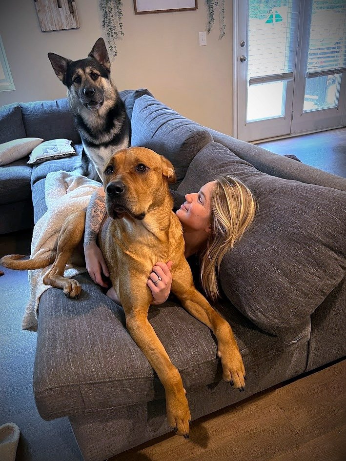 Alyssa on the couch with her dogs piled on her
