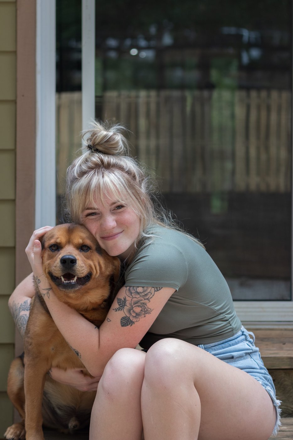 Alyssa, founder of The Pawlor, hugging one of her dogs
